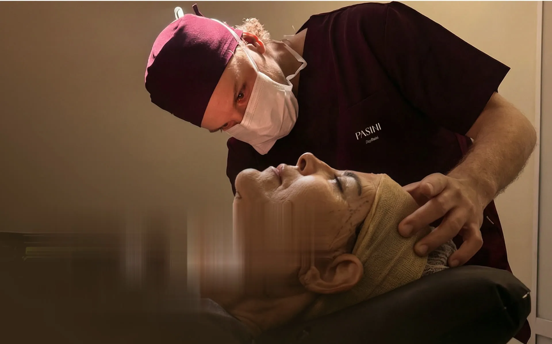 Médico da Clínica Pasini avaliando o rosto de uma paciente durante procedimento
